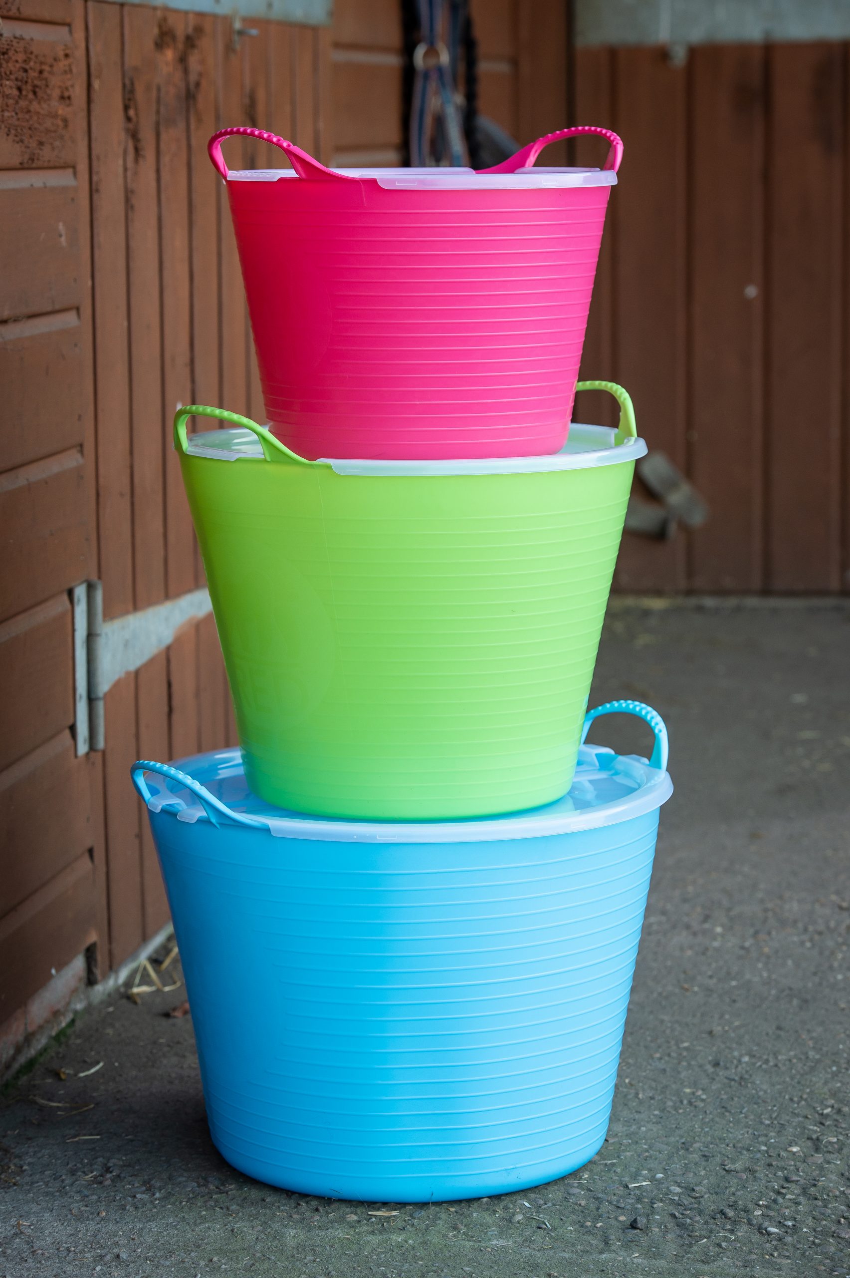 Tre Red Gorilla Lock Transparent LARGE-burkar staplade inomhus i färgerna rosa, grön och blå.