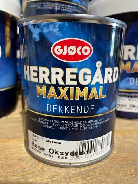 En burk Maximal base oxidröd 0,68LITER målarfärg på en träyta.