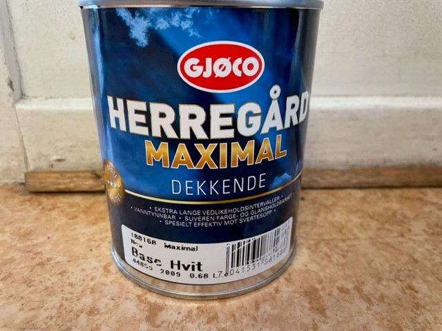 En burk Maximal base hvit 0,68LITER färg på en brun yta.