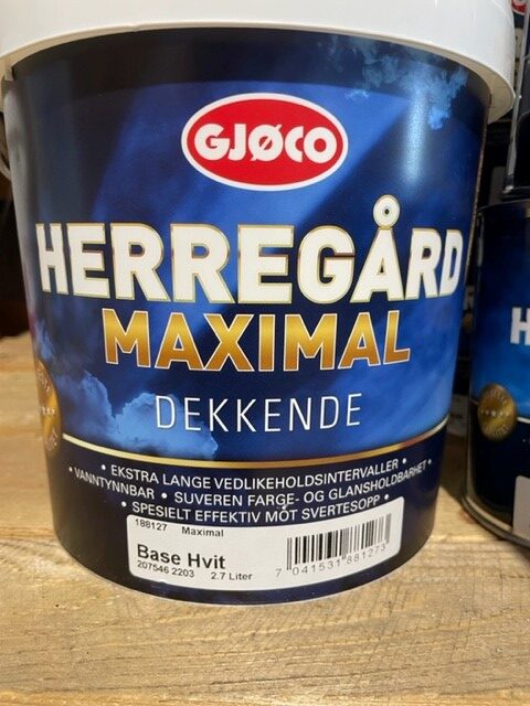 En 2,7 liters burk med vit färg på en trähylla.