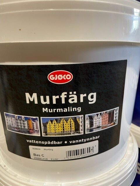 Svart färghink märkt Murfärg bas svart 9L med färgglada byggnader på etiketten.