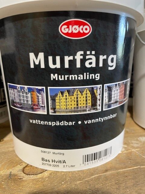 En 2,7 L Murfärg base hvit/A färghink med färgglada byggnadsbilder på etiketten.