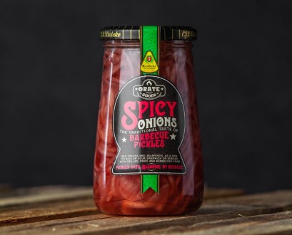 En burk med kryddiga lökar 370 ml på en träyta med mörk bakgrund.