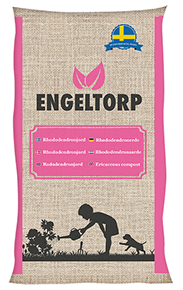 En säck i juteväv märkt RHODODENDRONJORD 50 LITER med ett barn och en hund i närheten.