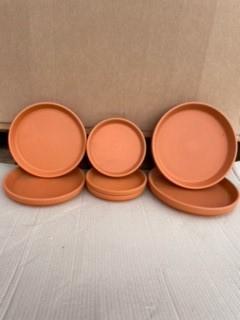 Fem stycken Lerfat 12 cm Rödlera orange lertallrikar på ljus yta med kartongbakgrund.