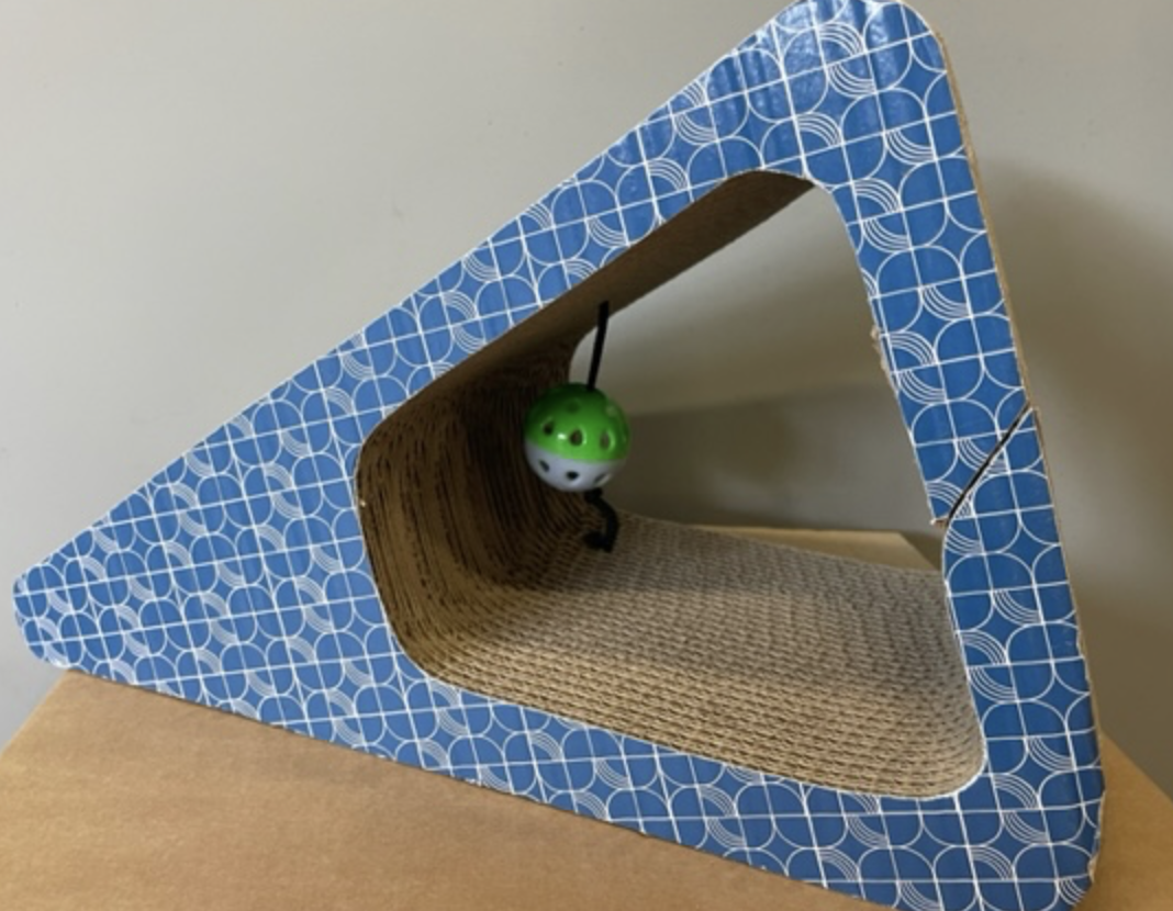 Katt triangel-blå triangulär kattskrapa med en grön och vit hängande bollleksak.