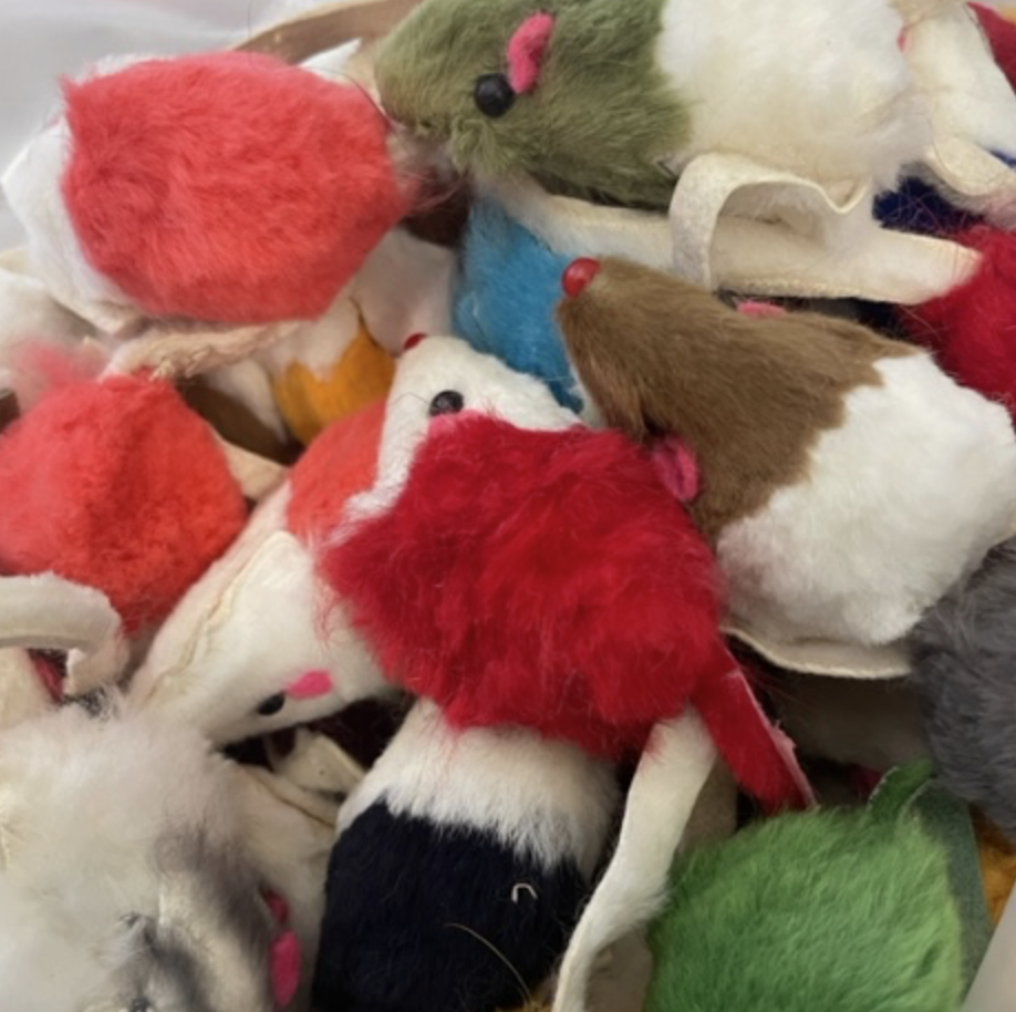 En hög med mus kattleksak leksaksmöss i rött, vitt, brunt och grönt luddigt tyg.
