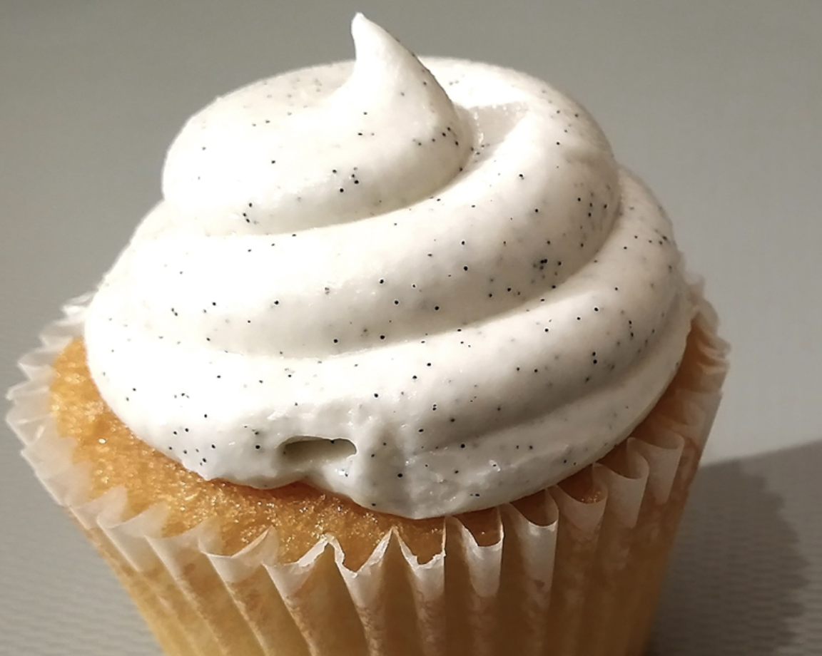 VANILJ AROM (25 ML) visas med vitspräcklig glasyr i en pappersliner på en ljus yta.