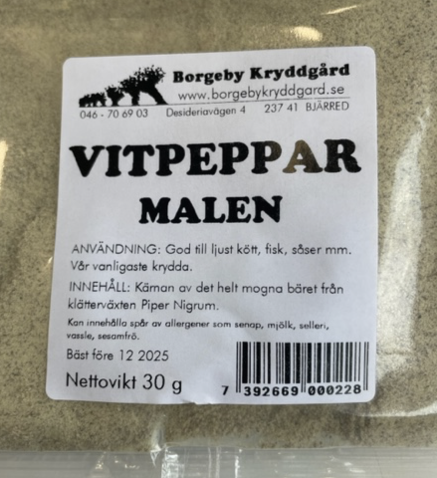 En genomskinlig kryddförpackning märkt VITPEPPAR MALEN (30 G) innehållande malen vitpeppar.