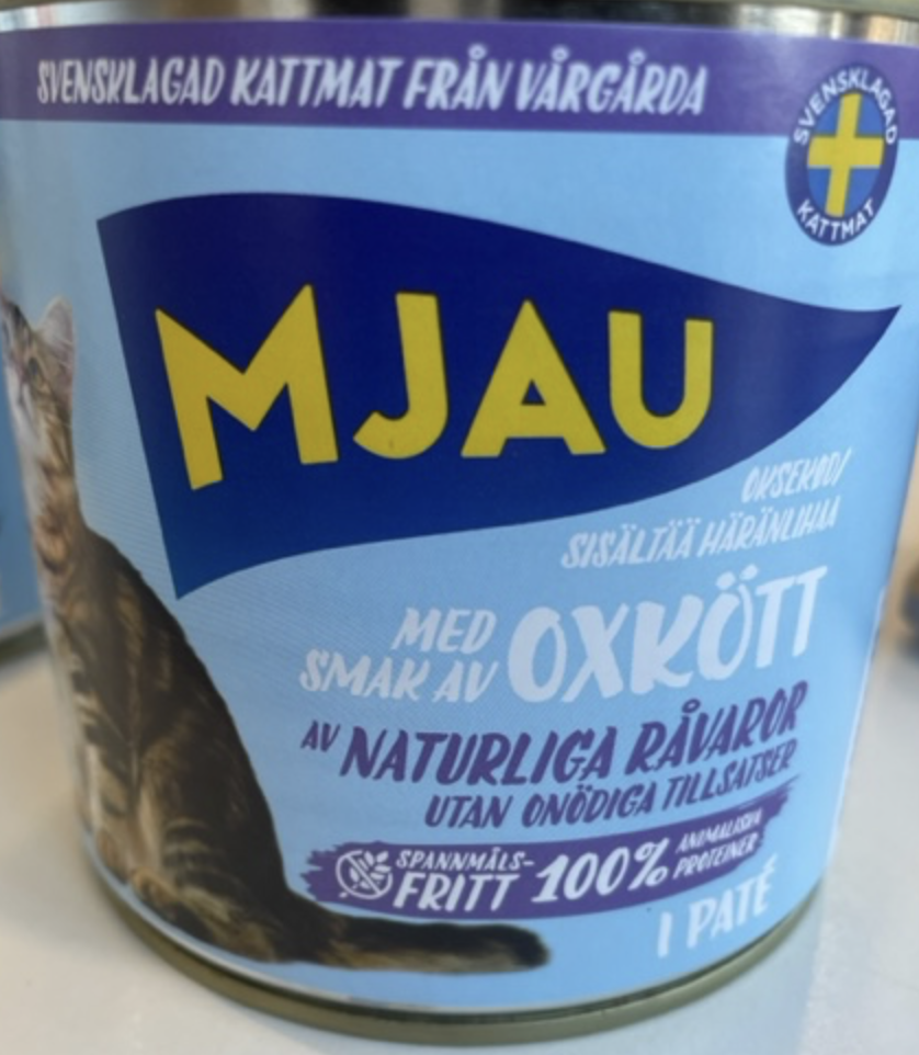 En burk MJAU OXKÖTT kattmat med blå och gul text och en katt på etiketten.