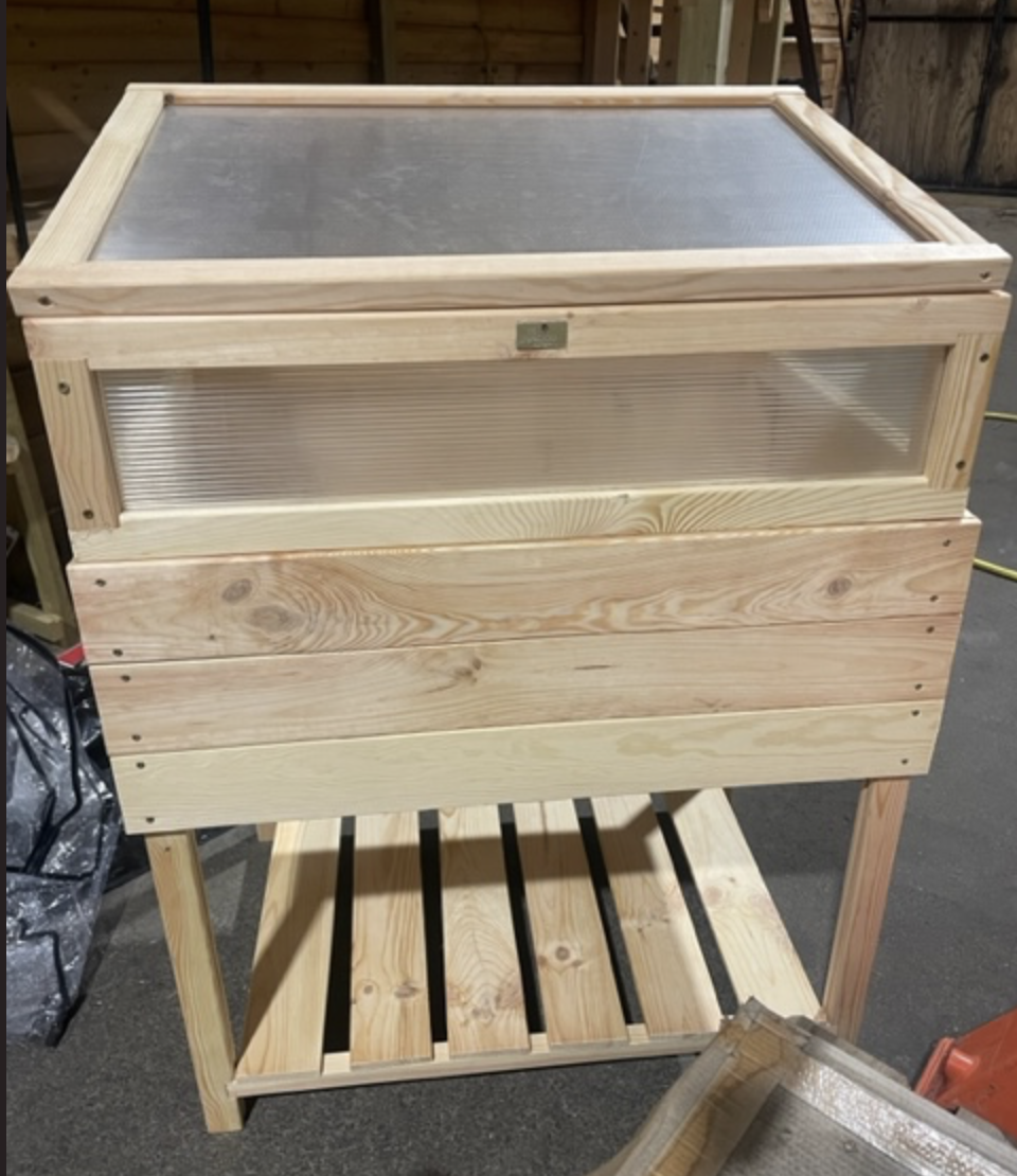 Växtbord H97/108 L79 med tydligt lock, hylla och placering på betonggolv.