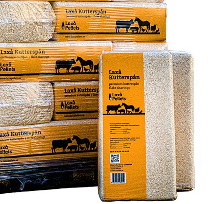 Påsar med spån från Laxå Kuttersrpan staplade på varandra, med djurikoner på förpackningen.