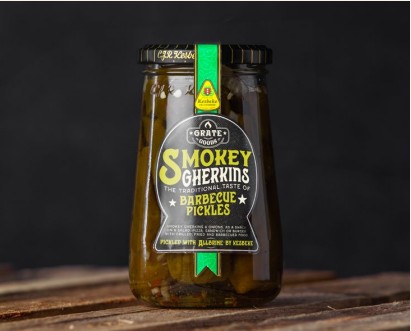 En 370 ml burk Smokey Gherkins på en träyta med mörk bakgrund.