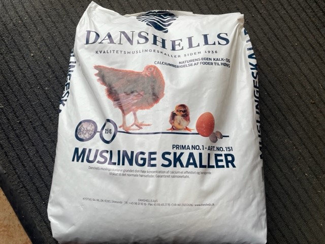 Påse med snäckskal 15 kg med illustrationer av höns, kycklingar och ägg på framsidan.