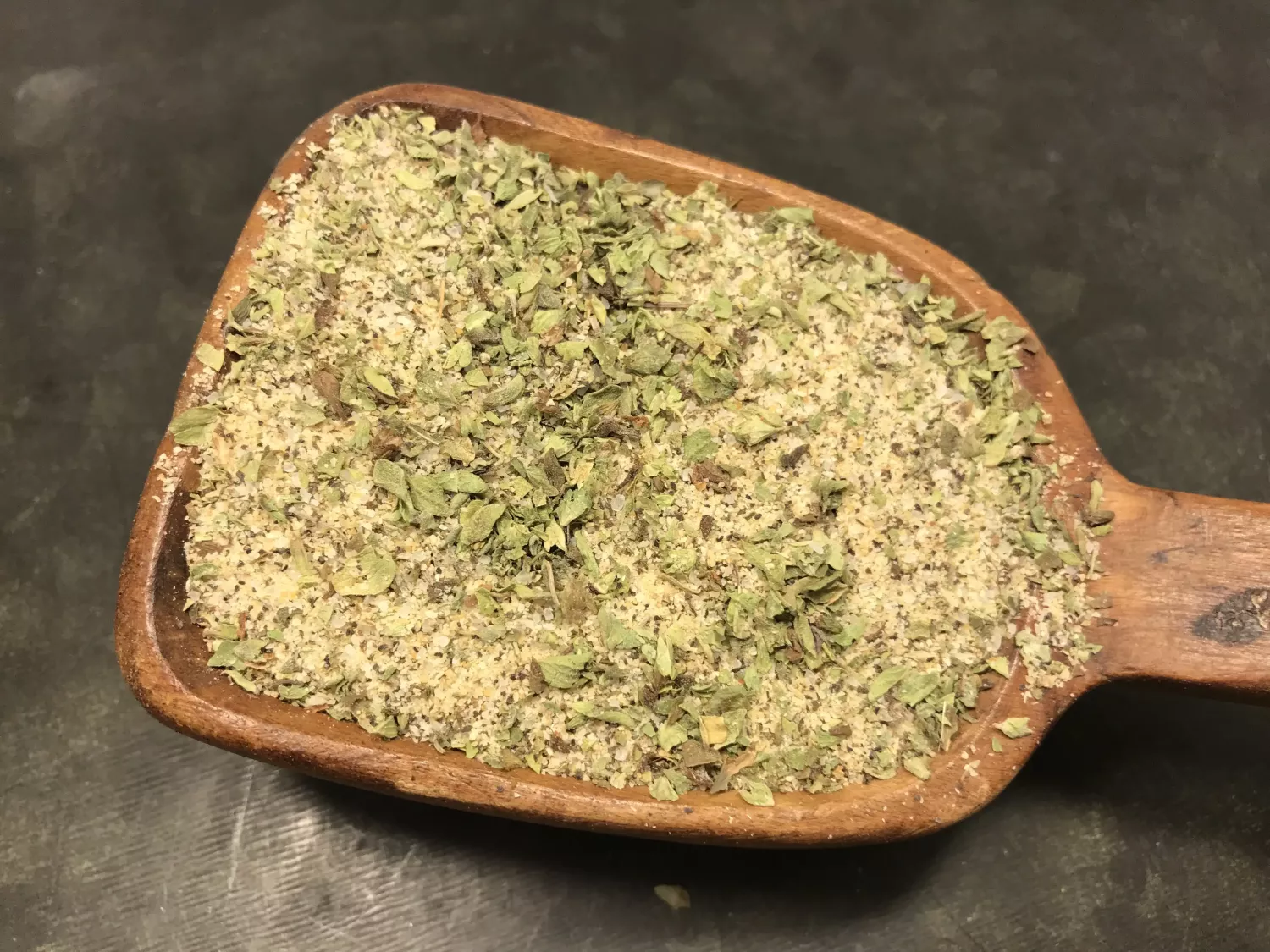 En träsked fylld med Grekisk Souvlaki, en blandning av gröna och beige torkade örter.