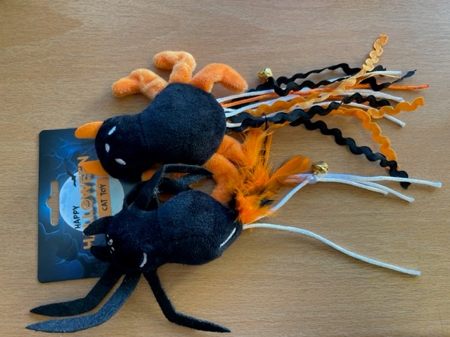 Two Spindeldjur med band och fjädrar, pingla kattleksaker med bjällror på en träyta.