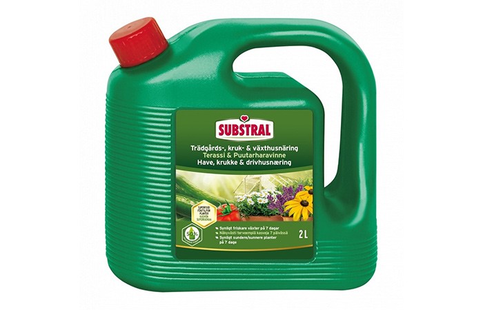 Grön 2L Drivhus-utomhusnäring-flaska med röd kapsyl och blometikett.