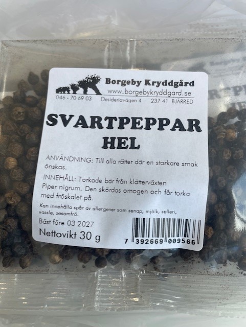 Ett paket svartpeppar hel hela svarta pepparkorn.