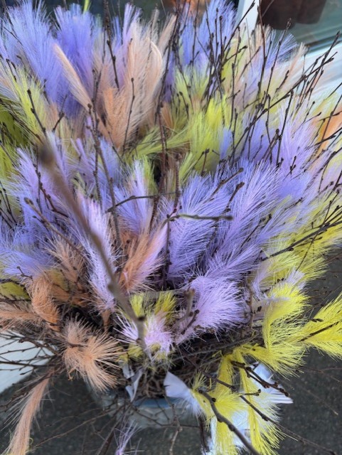 Fjäderris Syntetiskt: Mjuka, fjäderlika pastellfärgade blommor i lila, gult och persika med bruna stjälkar.