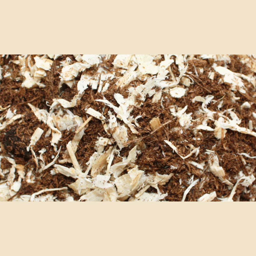Närbild av Torvmix, en lös blandning av bruna och vita flisor, idealisk för kompostering eller ströbäddar.