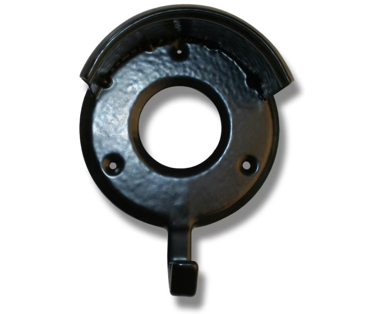 Tränshängare: Svart rund metallplatta med centralt och tre små monteringshål.