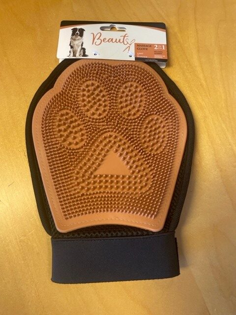 En brun Massagevante-handske för djurvård med tassavtryck på en träyta.