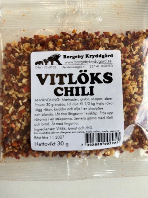 En genomskinlig förpackning med Vitlökschili 30g med svensk text på etiketten.