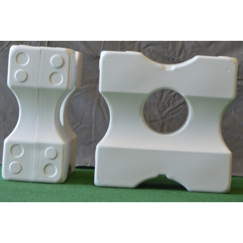 Två Cavaletti Block små vitbitar med unika former på grön och grå yta.