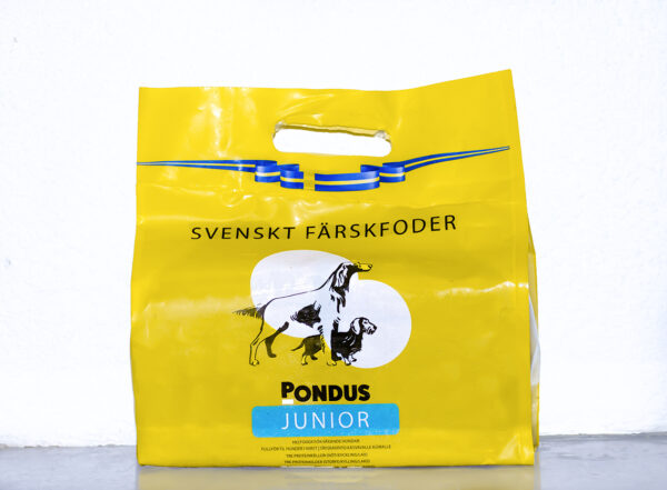 Gul påse med Pondus Junior småblock hundfoder med illustrationer av vuxna hundar och valpar.