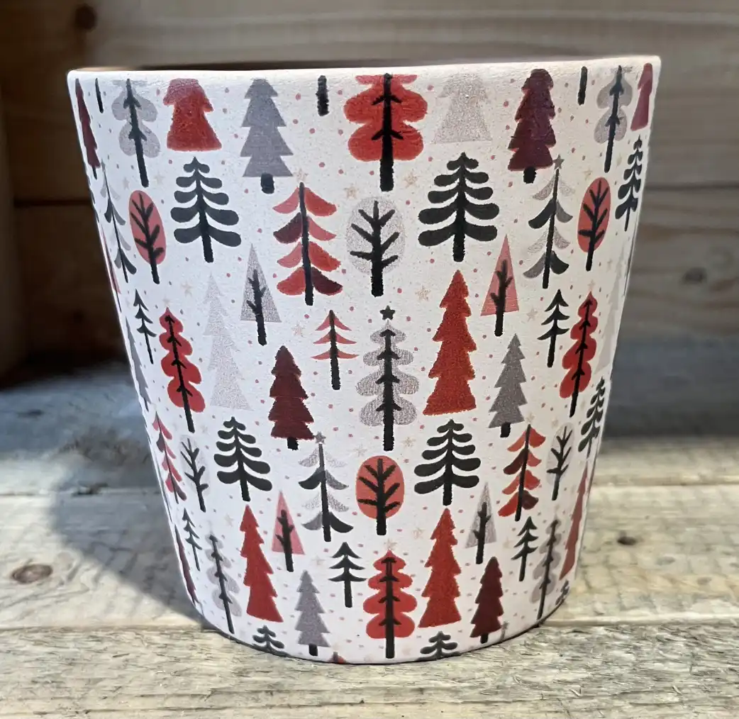 Winterwald vit keramikkruka med röda, grå och svarta trädmönster på en träyta.