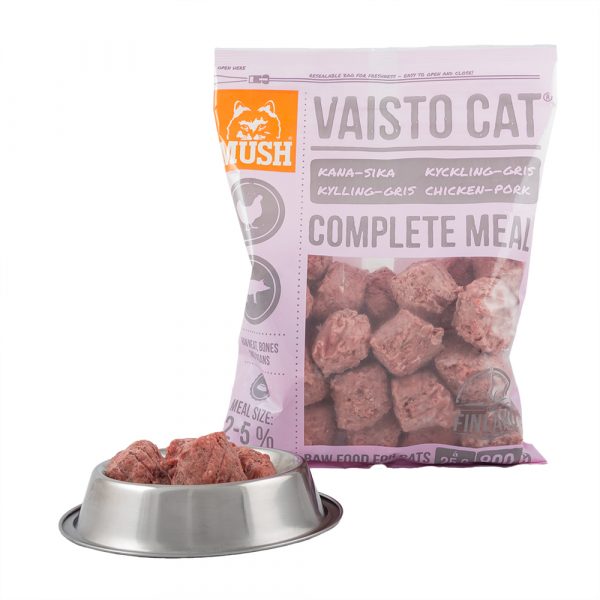 Mush Vaisto Cat Rosa-väska bakom en metallskål fylld med råa kattmatbitar.