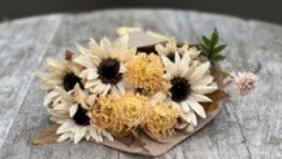 Bukett cream tork/siden: liten vit och gul bukett på rustikt trä.