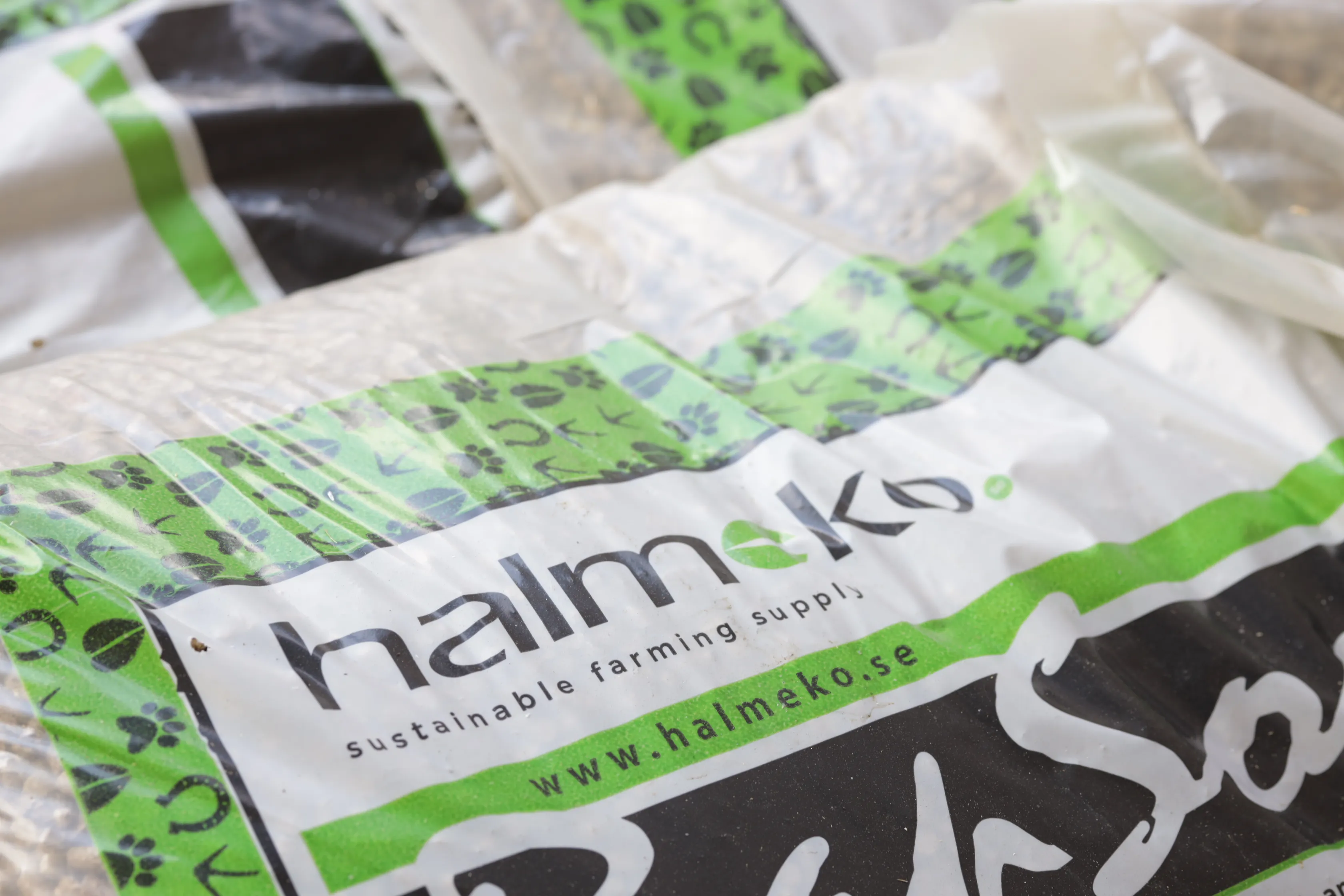 Närbild av en HalmeKo-väska för hållbart jordbruk med grön och svart design.