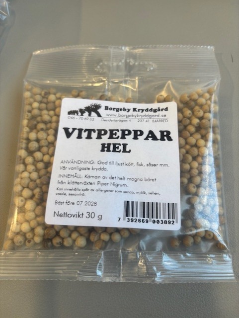 En 30 g påse Vitpeppar Hel hela vitpepparkorn på ett bord.
