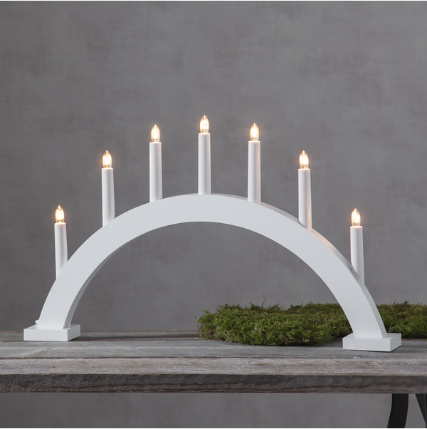 Star Trading Ljusstake Trapp: vit bågformad ljusstake med sju tända ljus på grå botten.