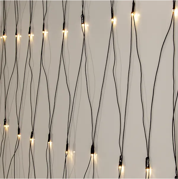 Star Trading Ljusnät Glänsande varmvita lampor hänger mot en slät vit vägg.