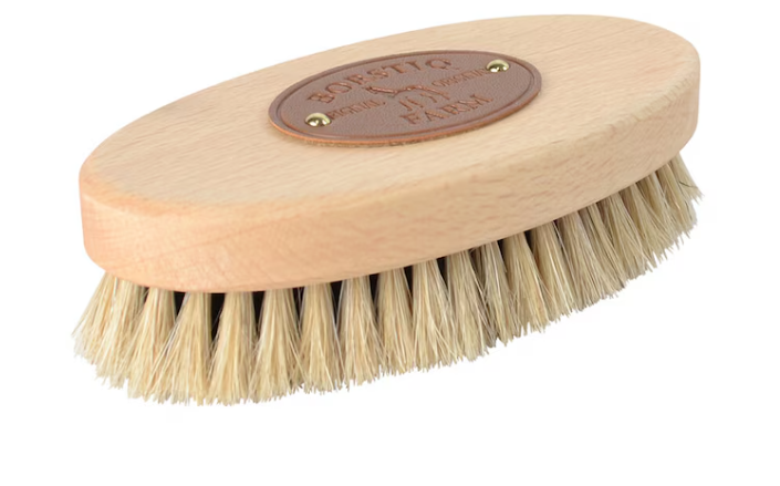 Huvudborste liten med tagelborst - oval träborste med ljusa borstar och brun läderetikett.