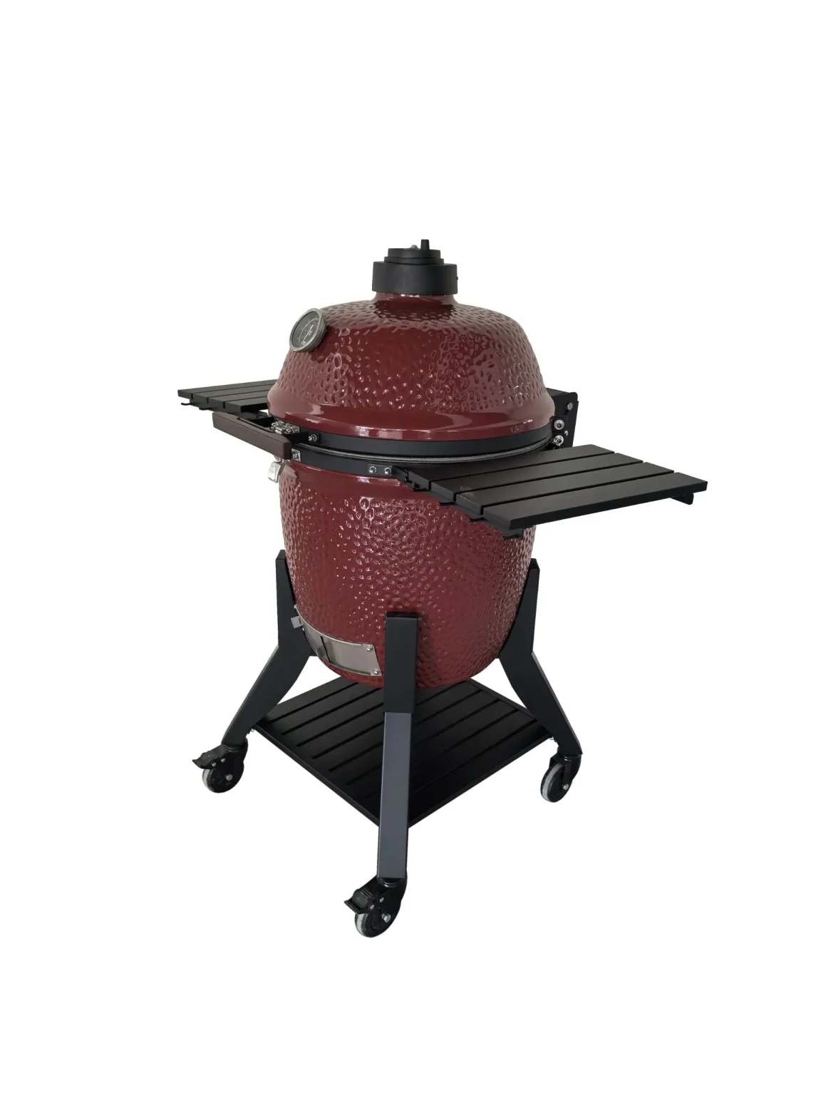 Kamadogrill i röd keramik med svarta hyllor och hjul på stativ.