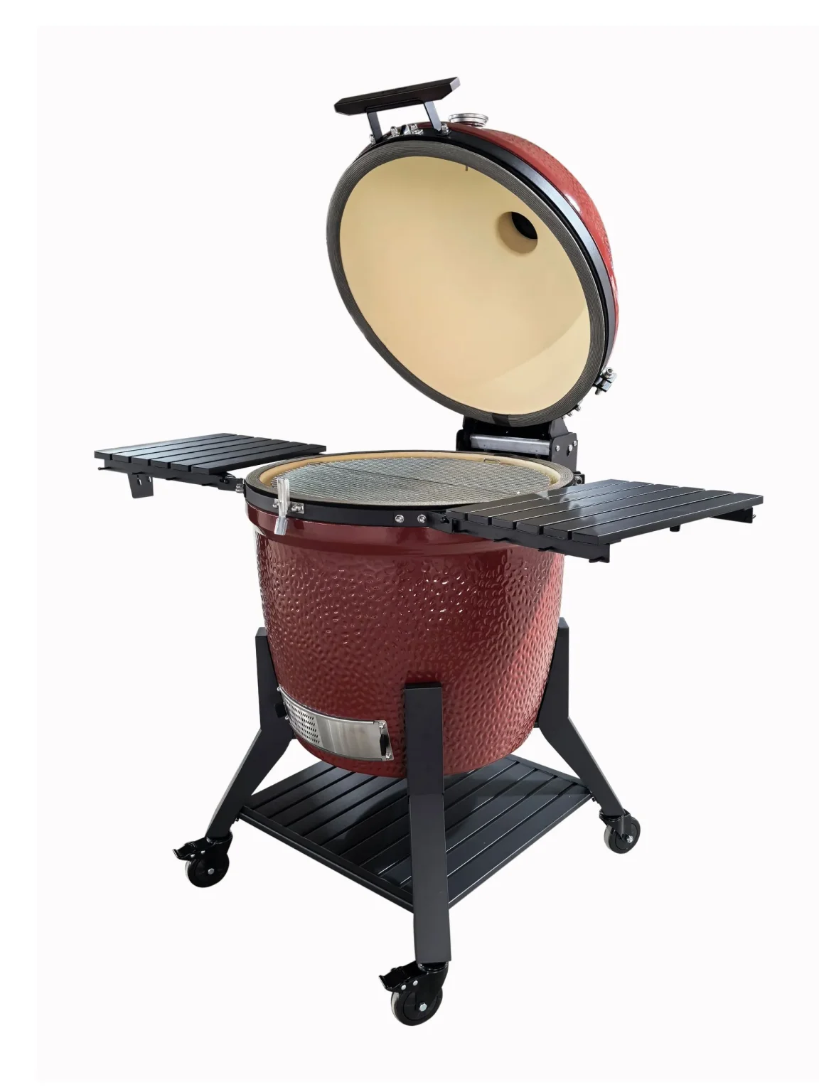 Kamadogrill i röd keramik med öppet lock, sidohyllor och hjul på underredet.